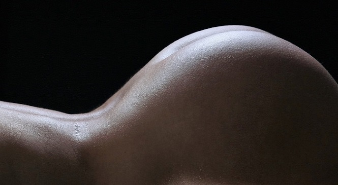 Nackter Hintern einer jungen Frau.