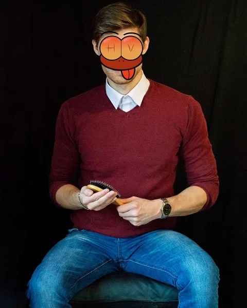 Spanking Kontakte: Junger Mann mit einer Haarbürste in der Hand sitzt auf einem Hocker und wartet darauf, einer frechen Dame den Po zu versohlen